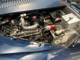 a blue car with an engine in it ' s trunk