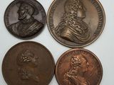 quatre pièces de bronze de tailles et de formes différentes sur une surface blanche