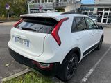 the rear end of a white car parked in a parking lot