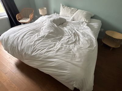 un lit recouvert d'une couette blanche dans une chambre