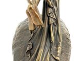 a statue of a woman holding a bird on a rock