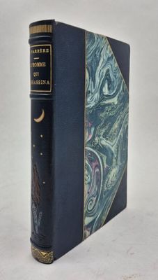 un vieux livre à la couverture bleue posé sur une table blanche