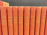 a stack of orange books sitting on top of a table