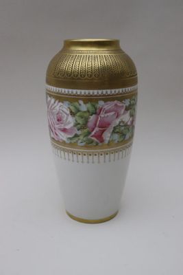 un vase blanc orné d'un liseré doré et de roses roses
