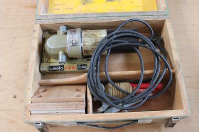 une boîte en bois contenant des outils, posée sur une table