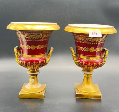 pair of red and gold vases sitting on top of a table