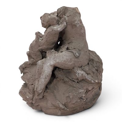 a clay sculpture of a man and a woman sitting on a rock