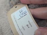 a person that is holding a teddy bear with a tag on it
