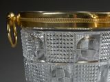 a glass vase with a gold lid on a table