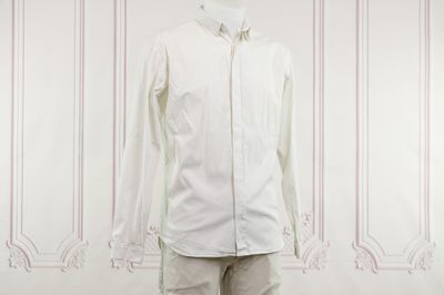 un mannequin masculin vêtu d'une chemise blanche et d'un pantalon beige