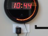 une horloge accrochée au mur, à laquelle sont reliés des fils