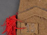 an image of a military uniform with a red tassel on it