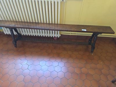 a wooden bench sitting on a tiled floor next to a radiator
