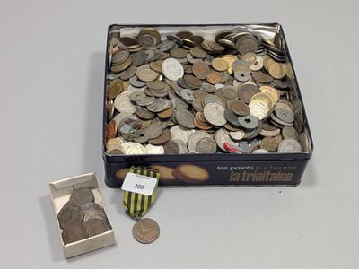 une boîte remplie de pièces et une médaille posées sur une table