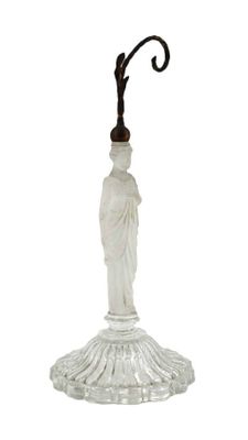 un bougeoir en verre surmonté d'une statuette
