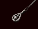 un vieux pendentif en diamant taillé, suspendu à une chaîne, sur fond noir