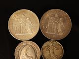 four different types of coins on a black surface
