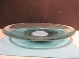 a glass bowl sitting on a plate on a table