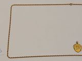 un gros plan d'un collier en or orné d'un cœur