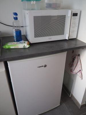un micro-ondes blanc posé sur une étagère à côté d'un four à micro-ondes