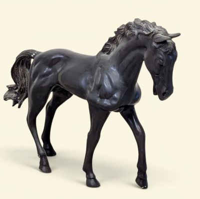 un cheval noir qui se tient debout sur une surface blanche