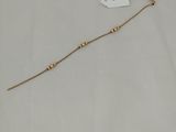 a close up of a gold beaded necklace with a tag on it
