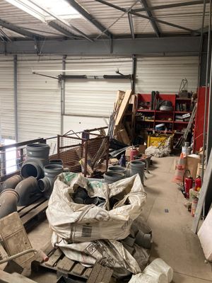 un gros tas de bric-à-brac dans un entrepôt où se trouvent de nombreuses boîtes