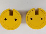two yellow electrical plugs on a white surface