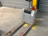 a fork lifter that is parked in front of a garage door