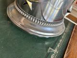 a silver cup with a flower in it on a table
