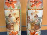 two vases with pictures on them sitting on a table