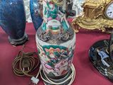 many vases and clocks on a table with a red table cloth