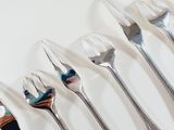 a lot of forks that are lined up on a table