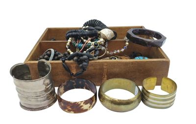 a wooden box filled with assorted jewelry and bracelets