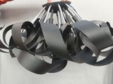 une personne tenant un lustre noir fabriqué à partir de bandes de métal