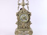une horloge posée sur un support sur une surface blanche