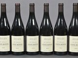 six bottles of wine are lined up in a row on a table