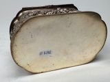 an antique silver purse with a metal frame on a white surface