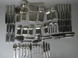 a lot of silverware on a table with spoons and knives