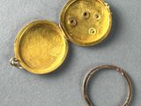an image of a gold locke with a ring on a table