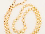 gros plan d'un collier de perles sur fond blanc