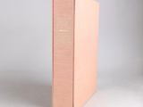 a pink box with a gold logo on the front