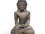 an image of a statue of a person sitting on a rock