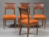 three wooden chairs with leather upholstered seats and a carved back