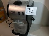 a coffee maker sitting on a shelf with a price tag attached to it