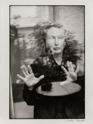 black and white photograph of a woman with her hands in front of her face