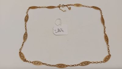 gros plan sur un collier en or portant une étiquette