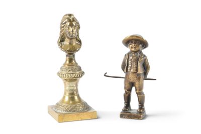 figurine en laiton représentant un homme avec un chapeau et une canne, à côté d'un buste d'un homme avec un chapeau et une canne