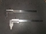 two different types of metal tools on a black surface
