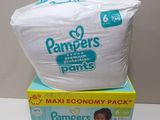 two boxes of diapers sitting on top of each other on a table